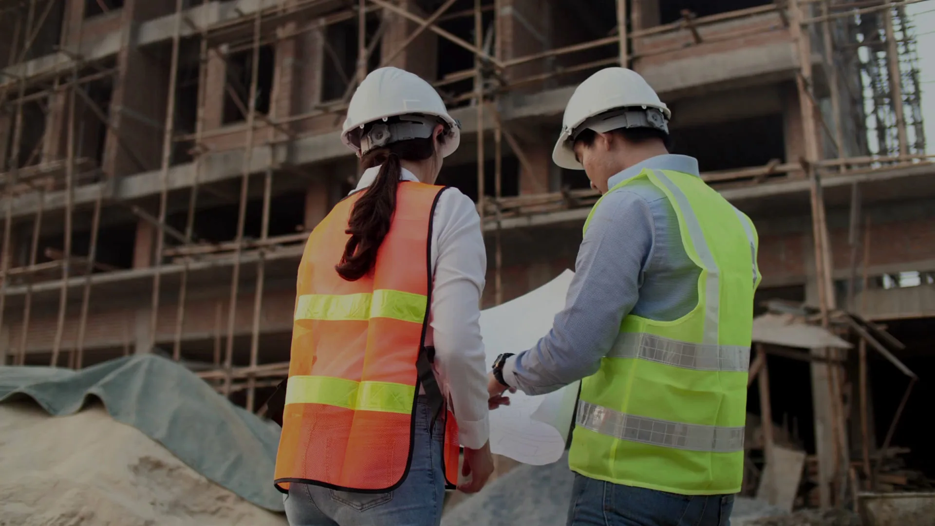 TGV Construction Group project managers reviewing building plans on a construction site
