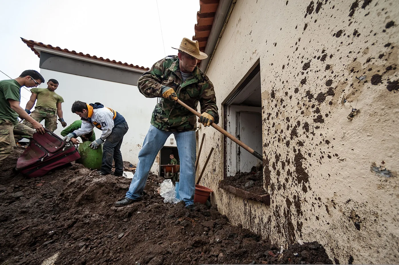 Restoration crew clearing flood debris from a house