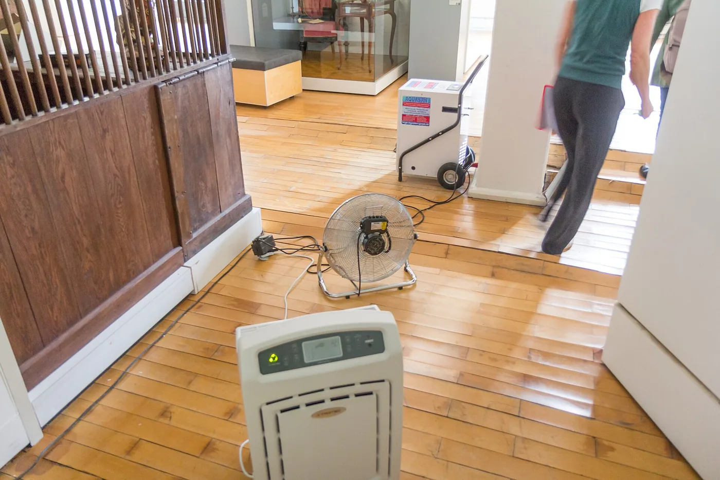 Fan and dehumidifier drying a wet hardwood floor