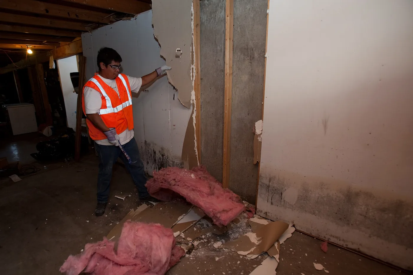 Contractor removing mould-damaged drywall