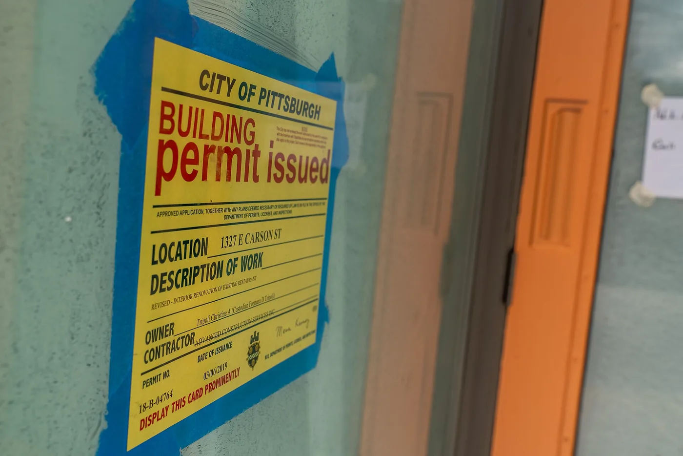Building permit posted on a door during renovation