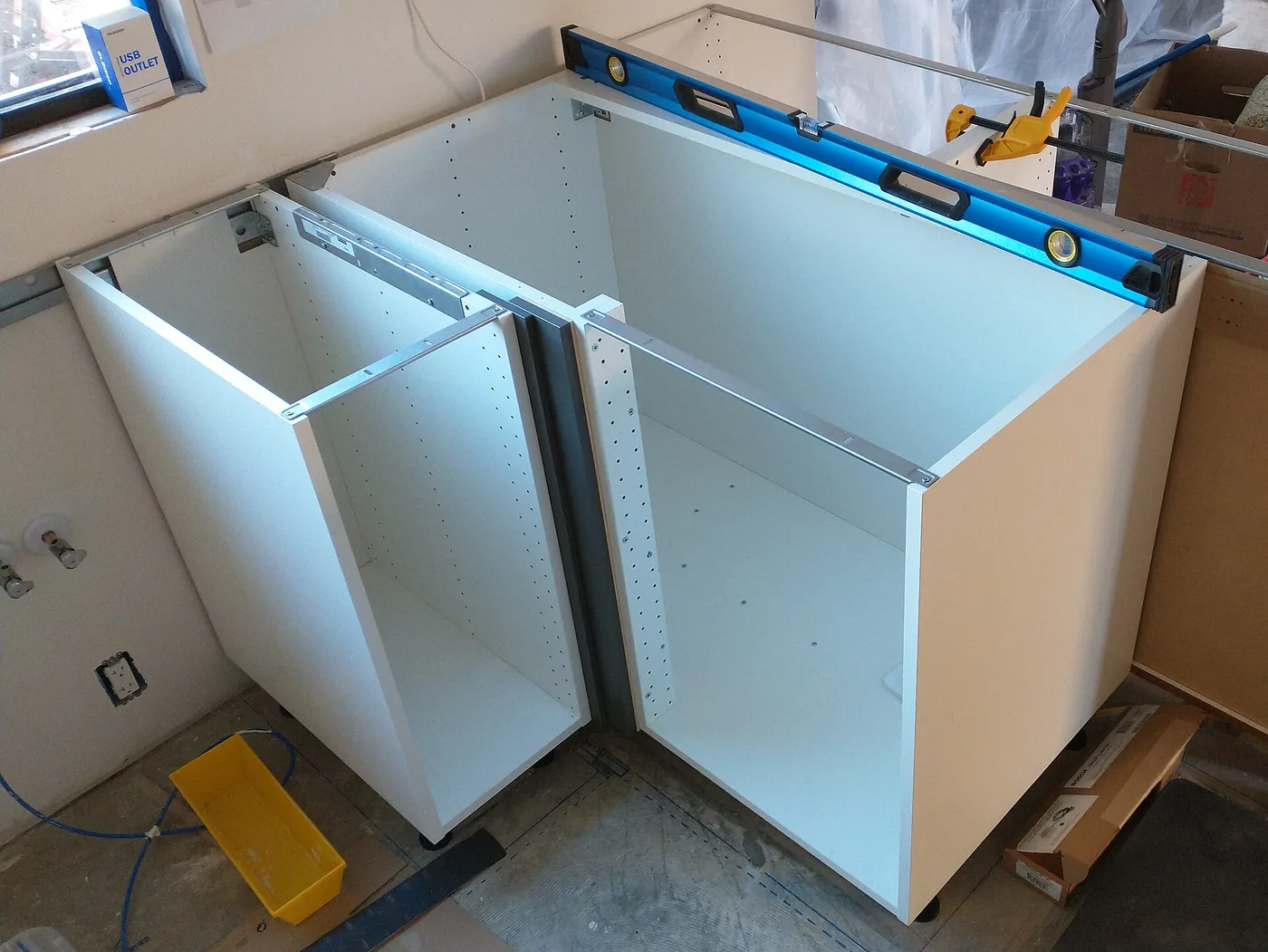 Kitchen base cabinets being levelled during installation