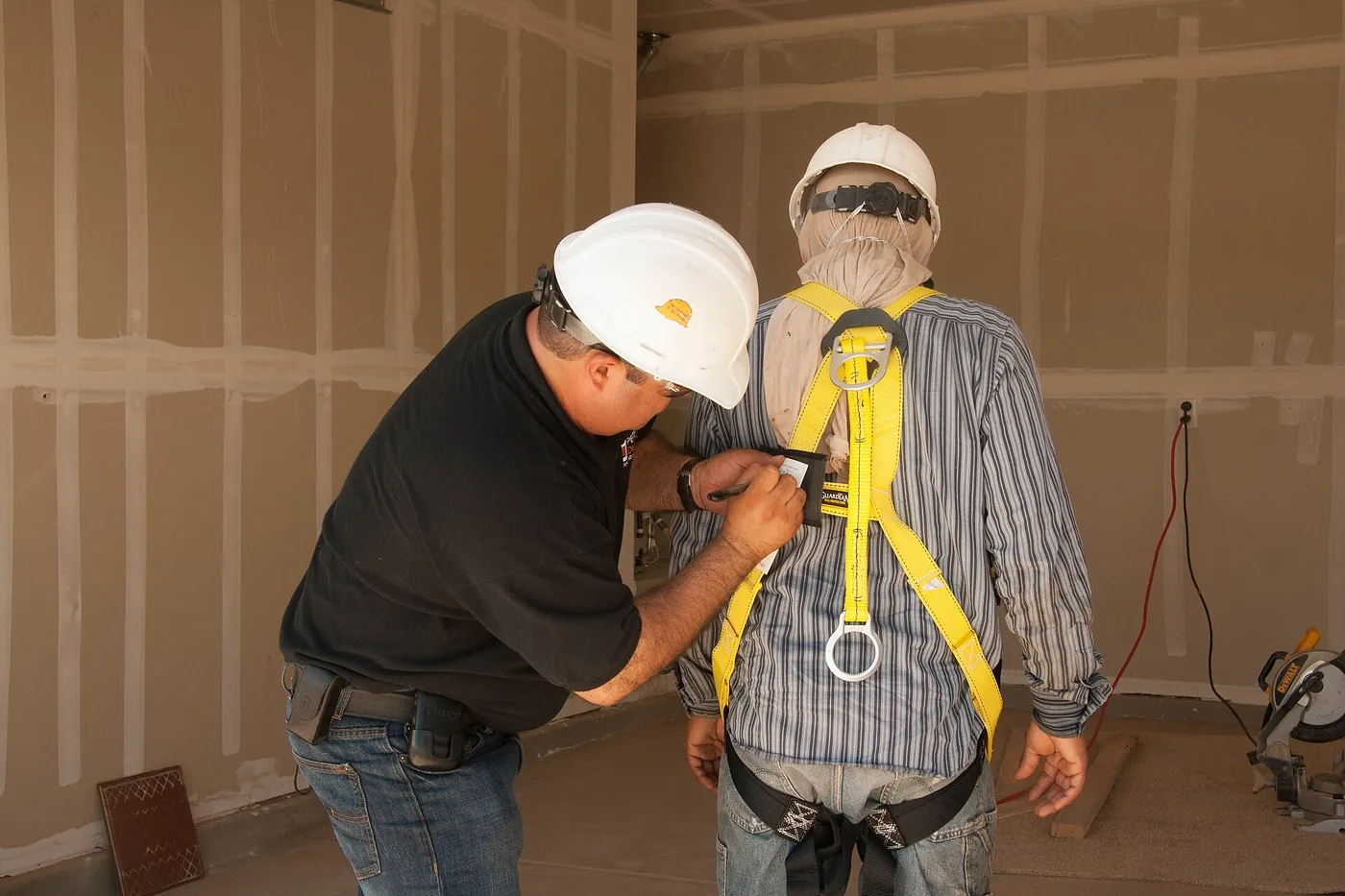 Contractors checking safety gear before drywall work