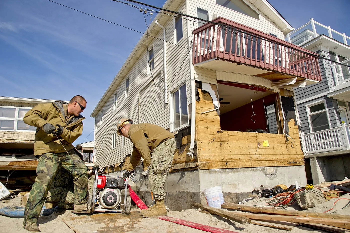 Crew pumping water away from a damaged house